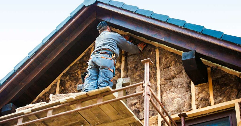 Handwerker beim Dämmen des Hauses.